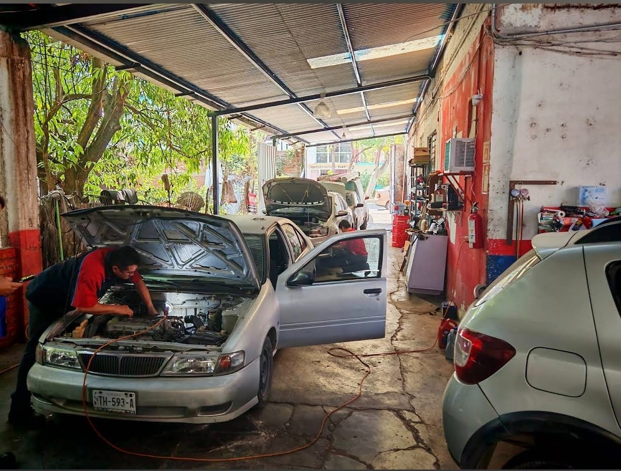 Mecánicos de Josari trabajando en un auto dentro del taller en Tuxtla Gutiérrez